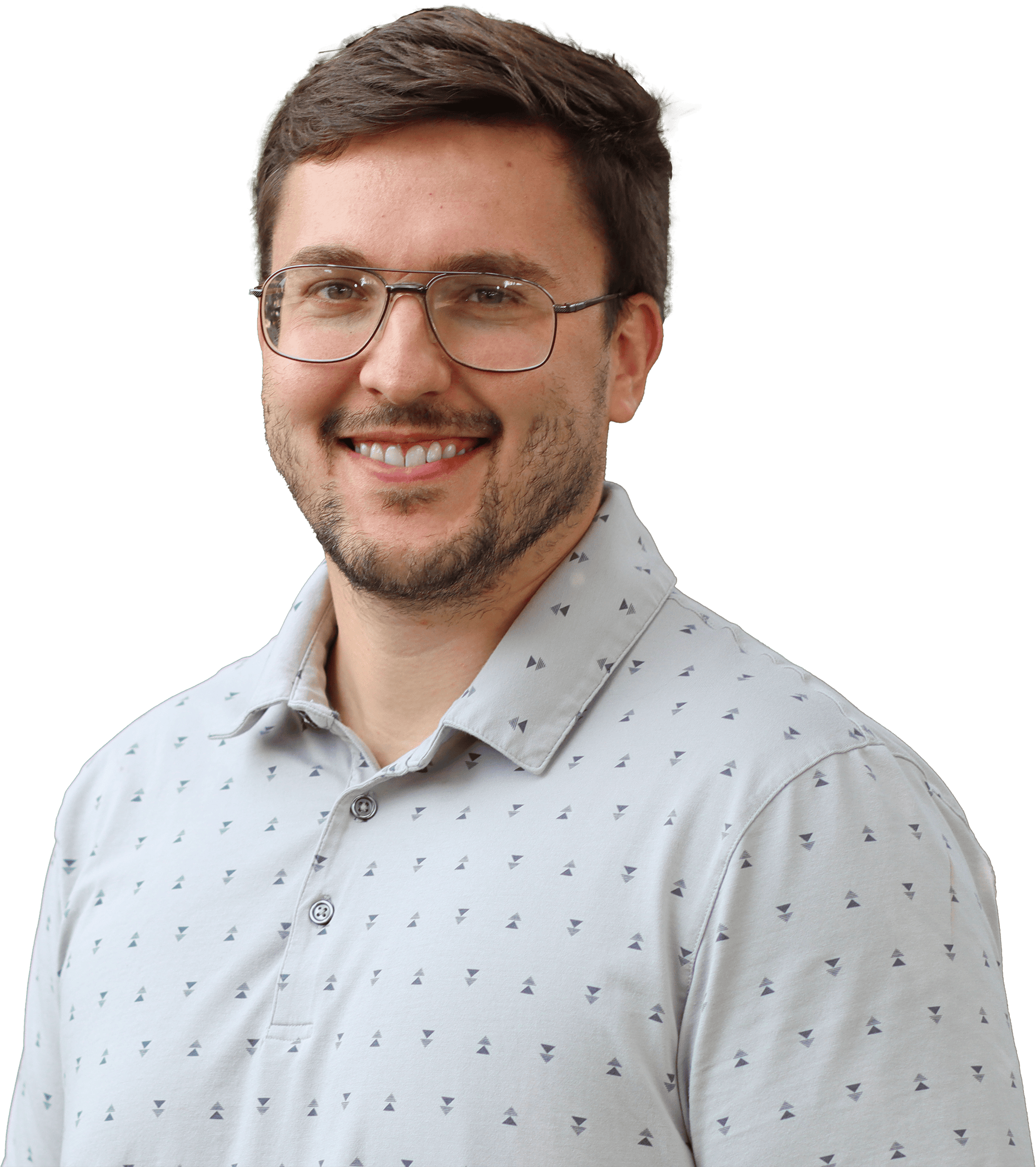 Smiling man with short dark hair and glasses in a light patterned shirt, close-up portrait.